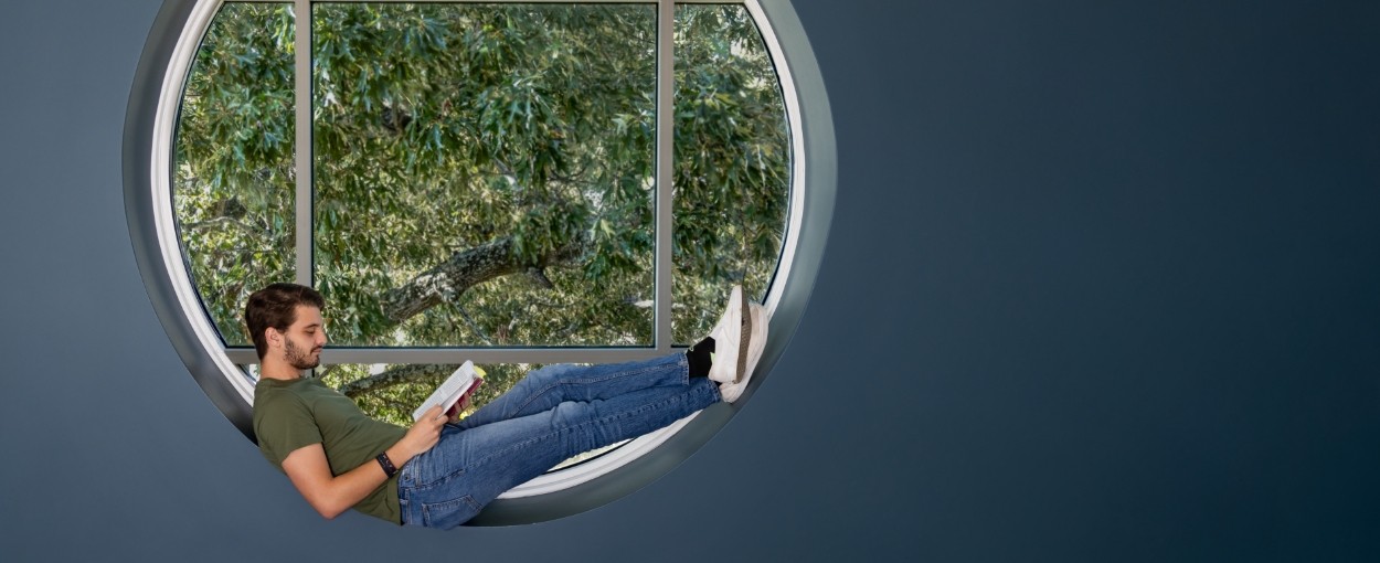 student reading a book in the window