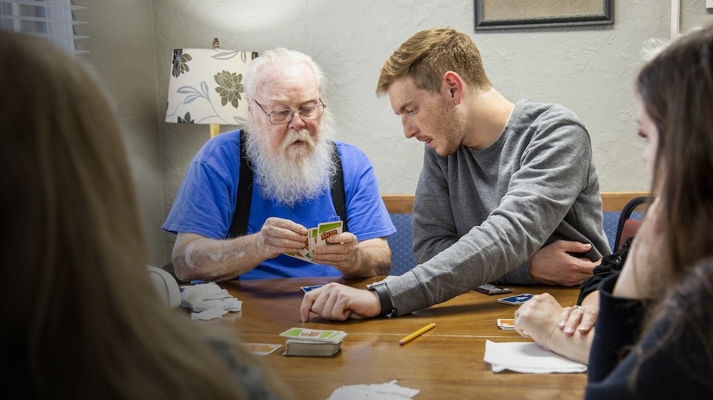 student playing cards with nursing home member