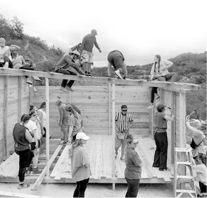 black and white image of men building a house