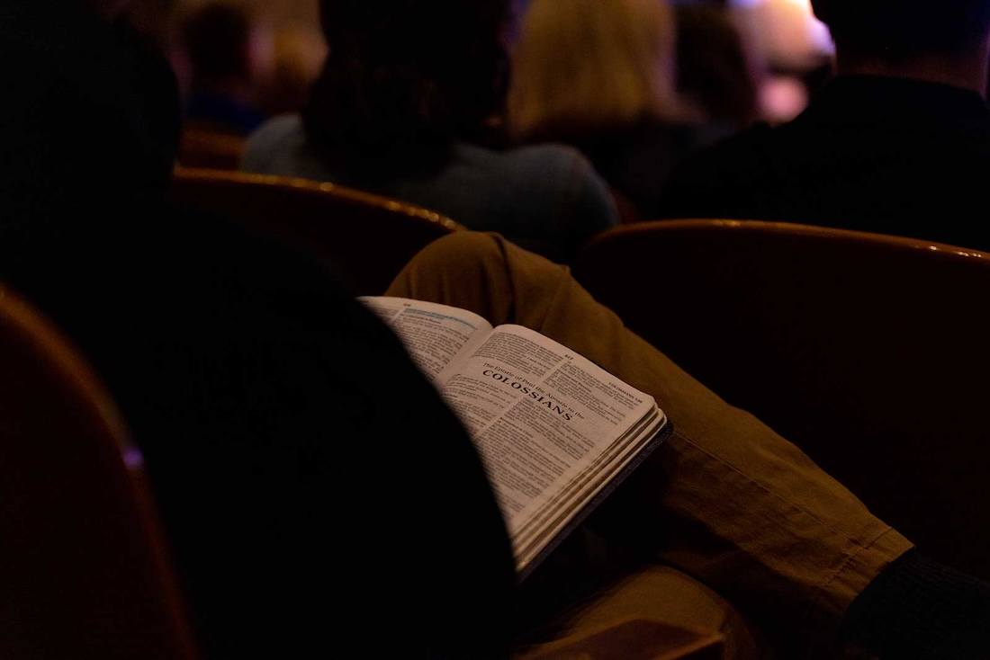 A student holds a Bible in their lap during chapel