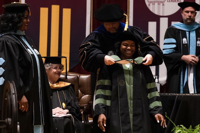 A DBH student on stage at graduation