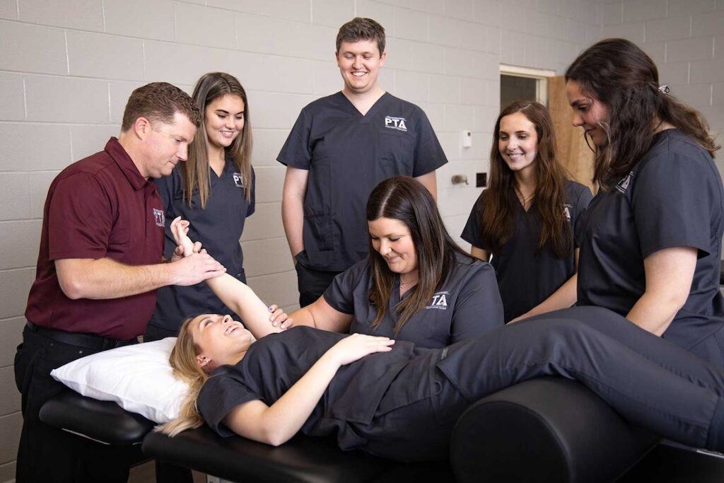 A group of pta students watching a stretching demonstration