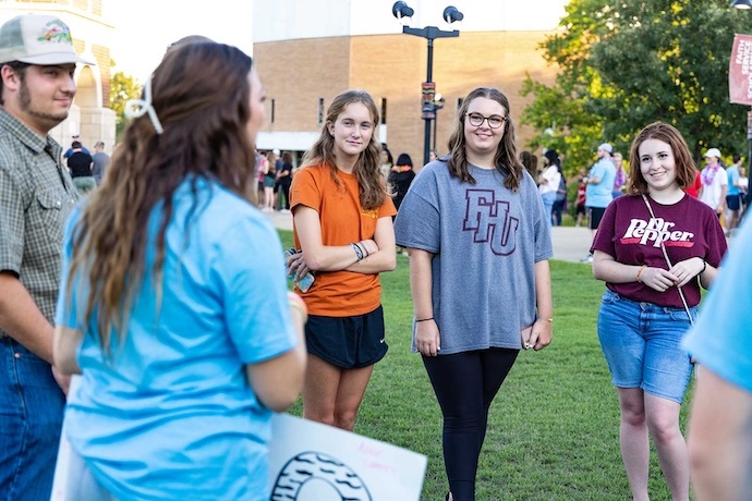 A group of students have a conversation during an event in the commons