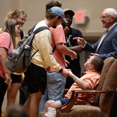 Students meet with the speaker on stage after chapel