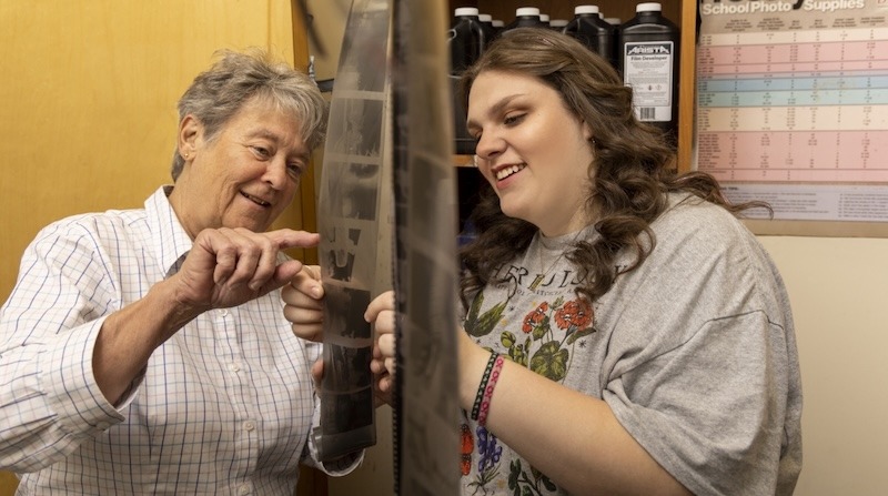 student and teacher looking at films