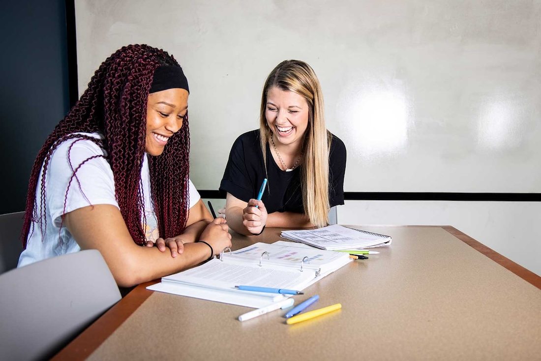 Two students working together in one of the library's study rooms