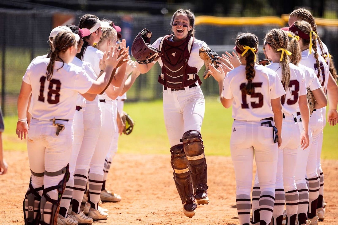 A group of softball players celebrating a good play