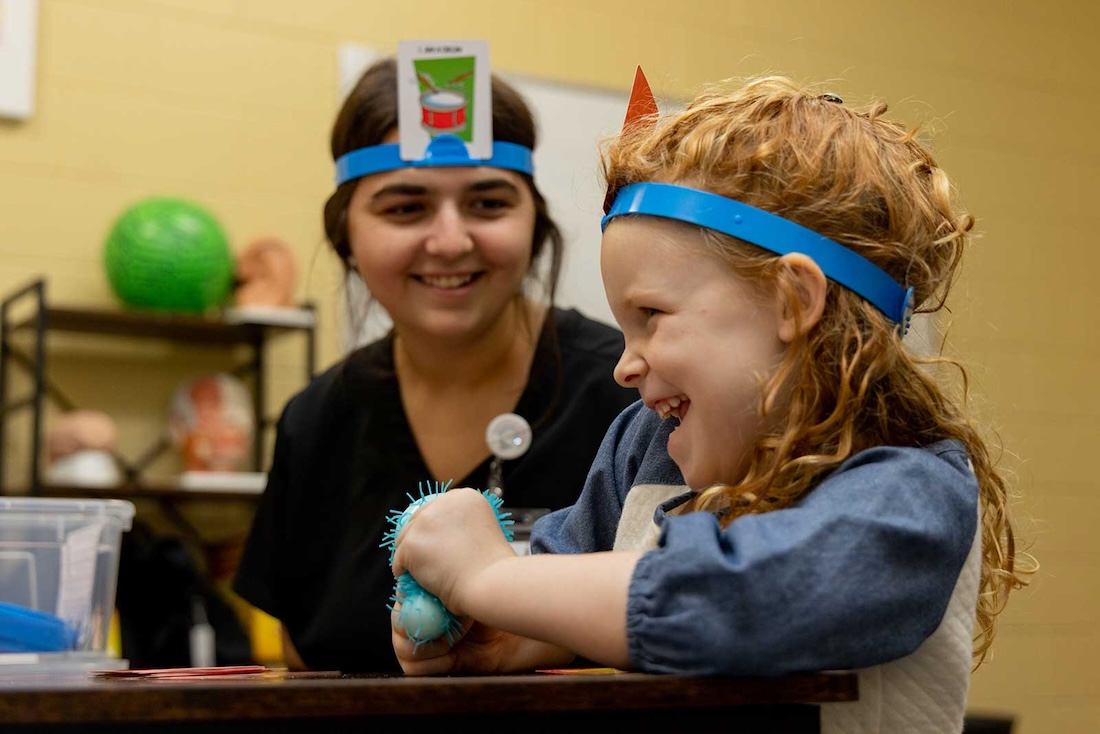 A student working with a child at the speech clinic on campus