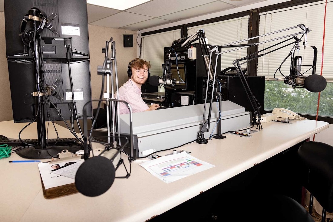 A student broadcasting in the campus radio station, 91.5 WFHU The Lion