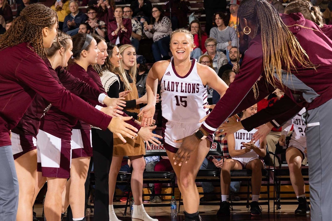 A member of the women's basketball team runs onto the court after she is announced